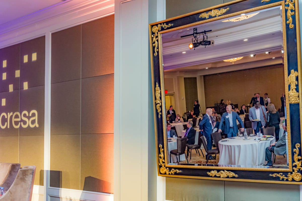 Cresa conference guests reflected in an ornate mirror inside the program room
