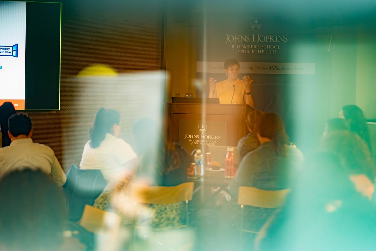Johns Hopkins Bloomberg School of Public Health speaker photographed through layers of color and audience movement