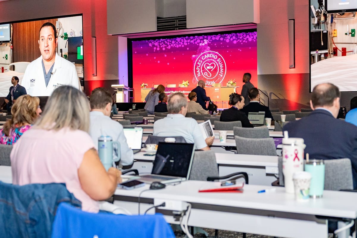 Physician presenting with the summit audience visible in the foreground