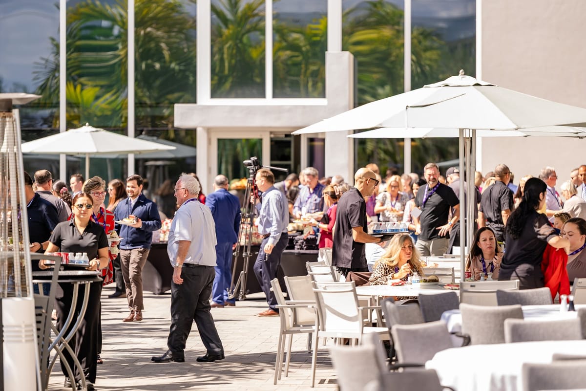 Summit attendees networking outside beside the waterfront venue