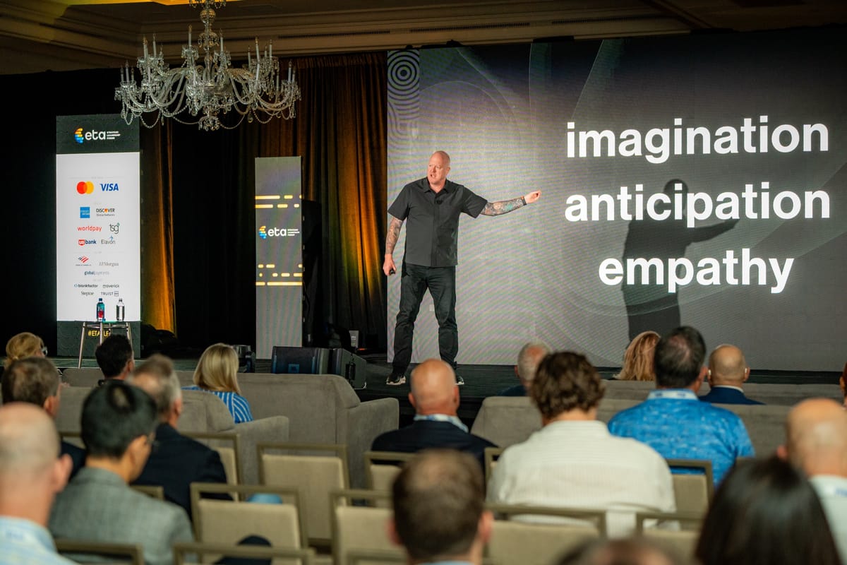 Keynote speaker addressing an audience beneath the words imagination, anticipation, and empathy