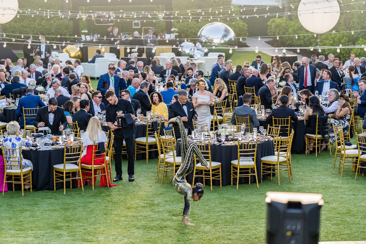 Wide view of the full TAG Advisors celebration dinner with guests seated across the lawn