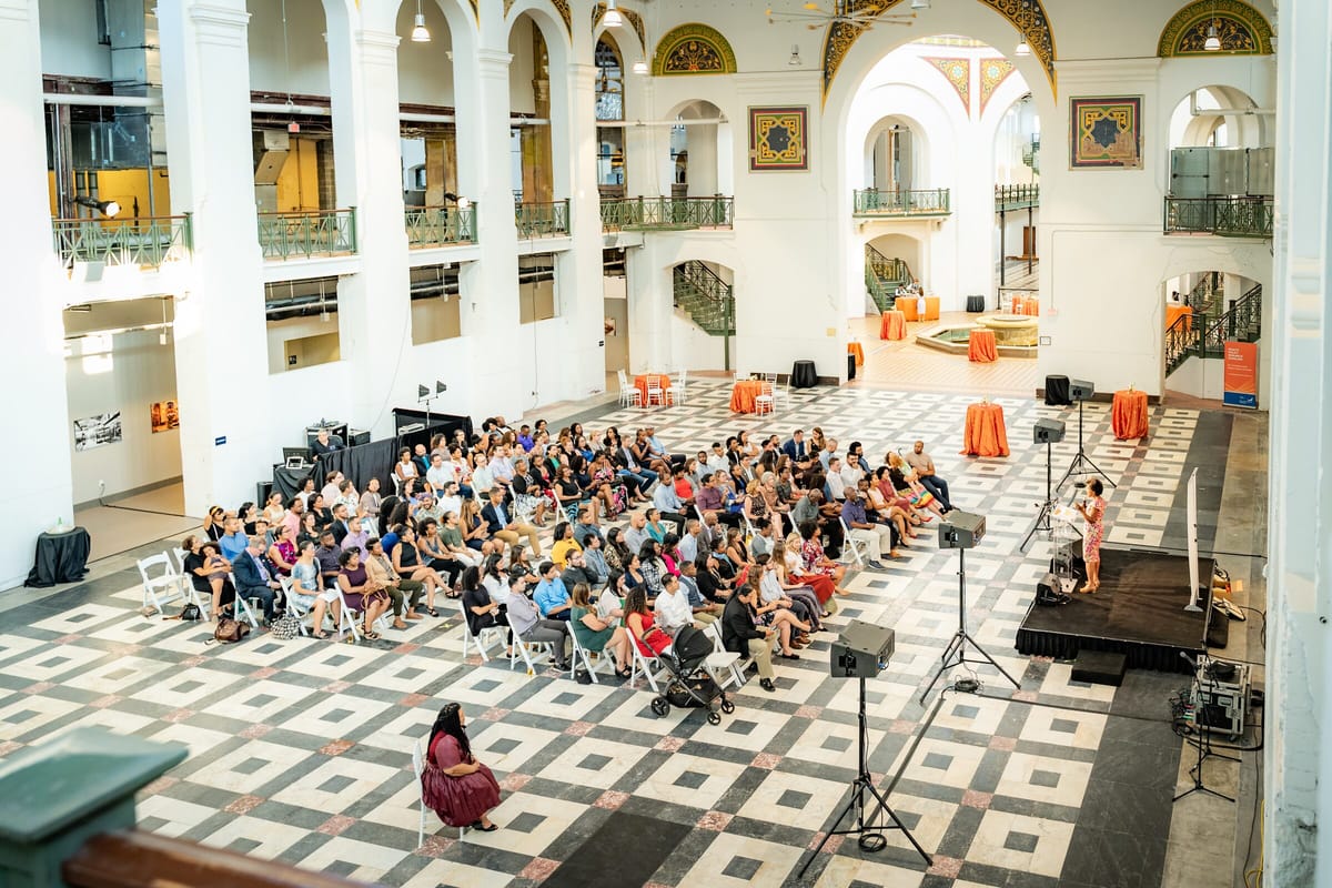 Seated audience of scholars and families at a Health Policy Research Scholars ceremony in a grand hall
