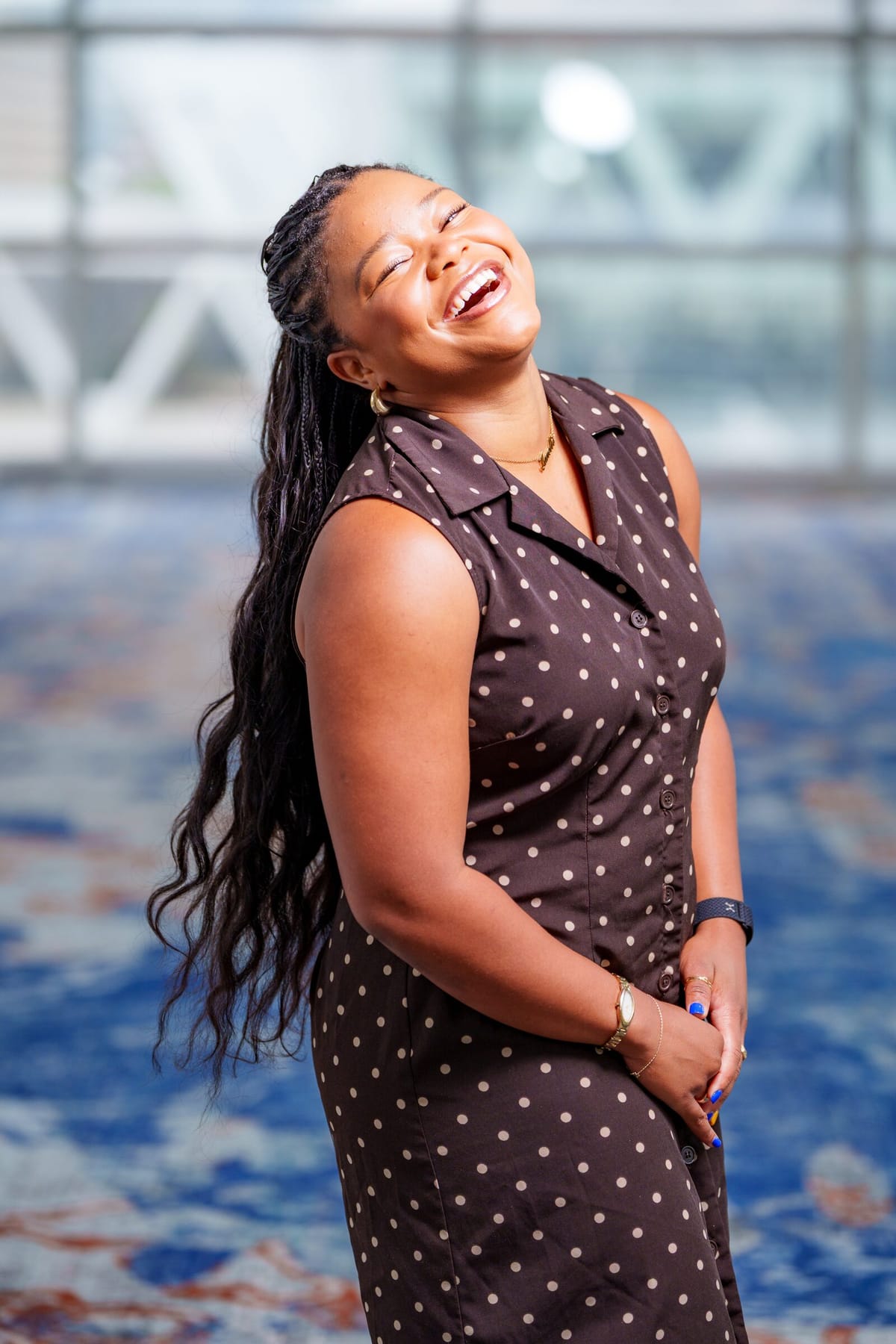 Scholar headshot with a softly blurred convention-center backdrop