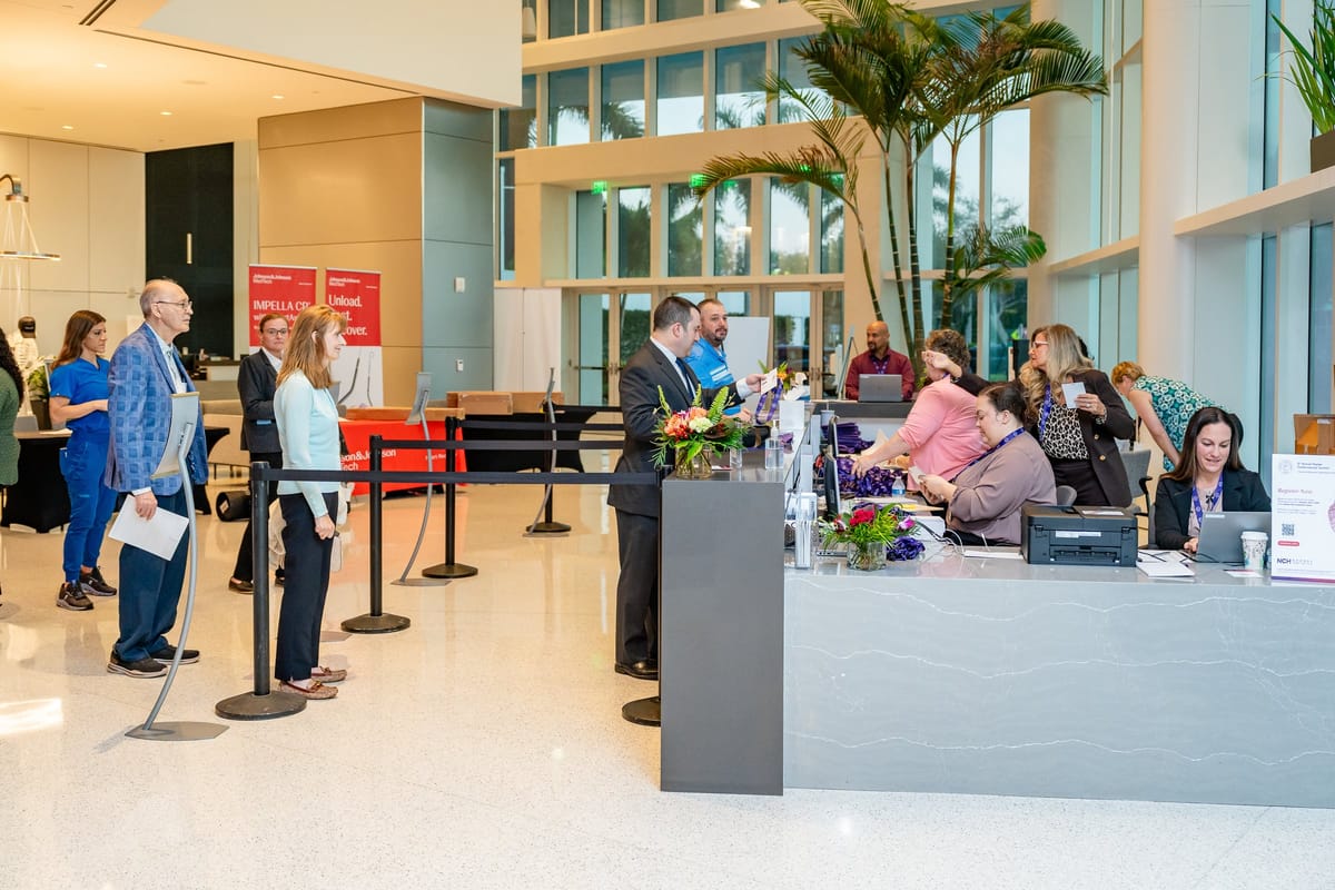 Attendees arriving and checking in inside the bright conference venue