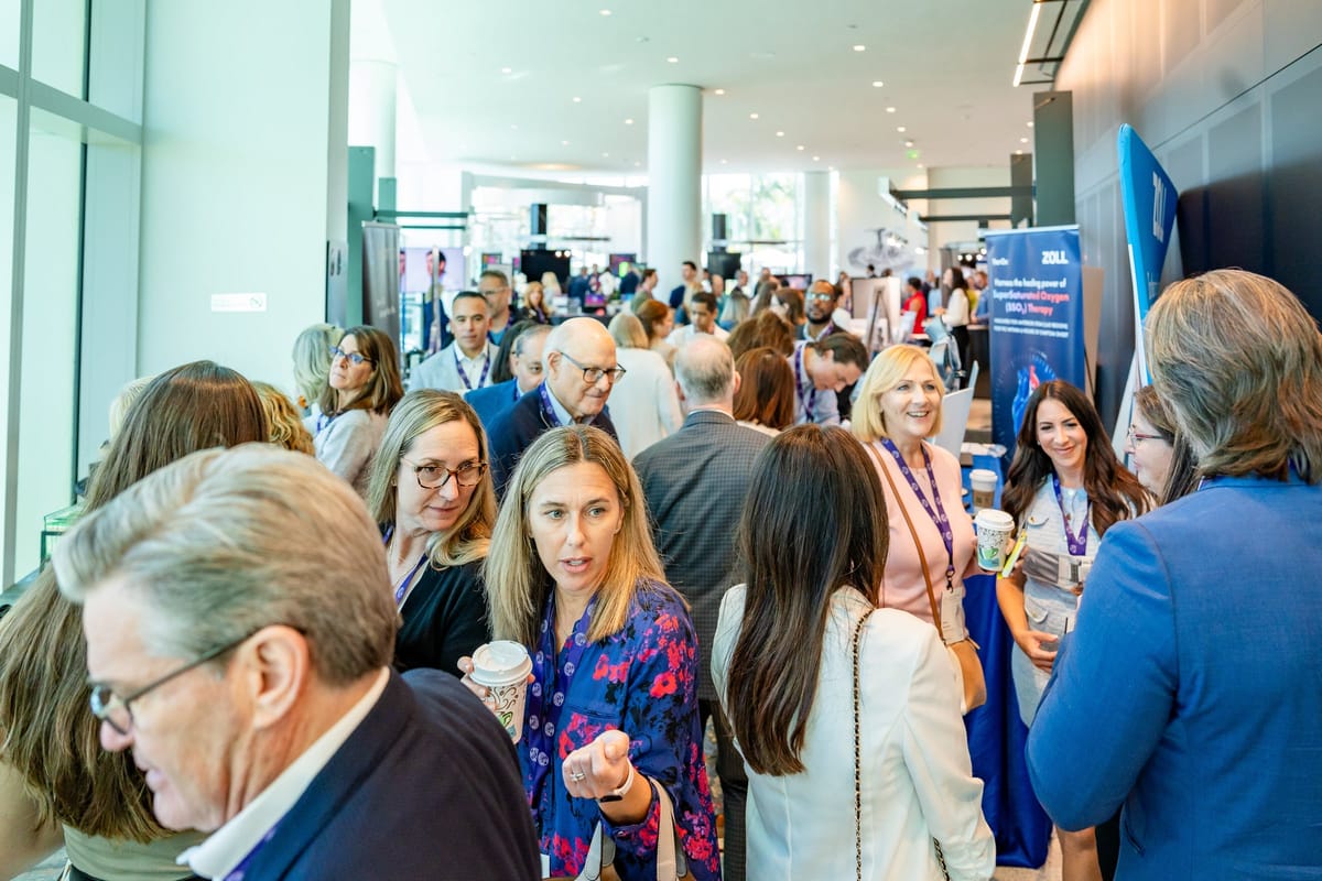Busy cardiovascular summit exhibitor floor filled with attendees and sponsor displays