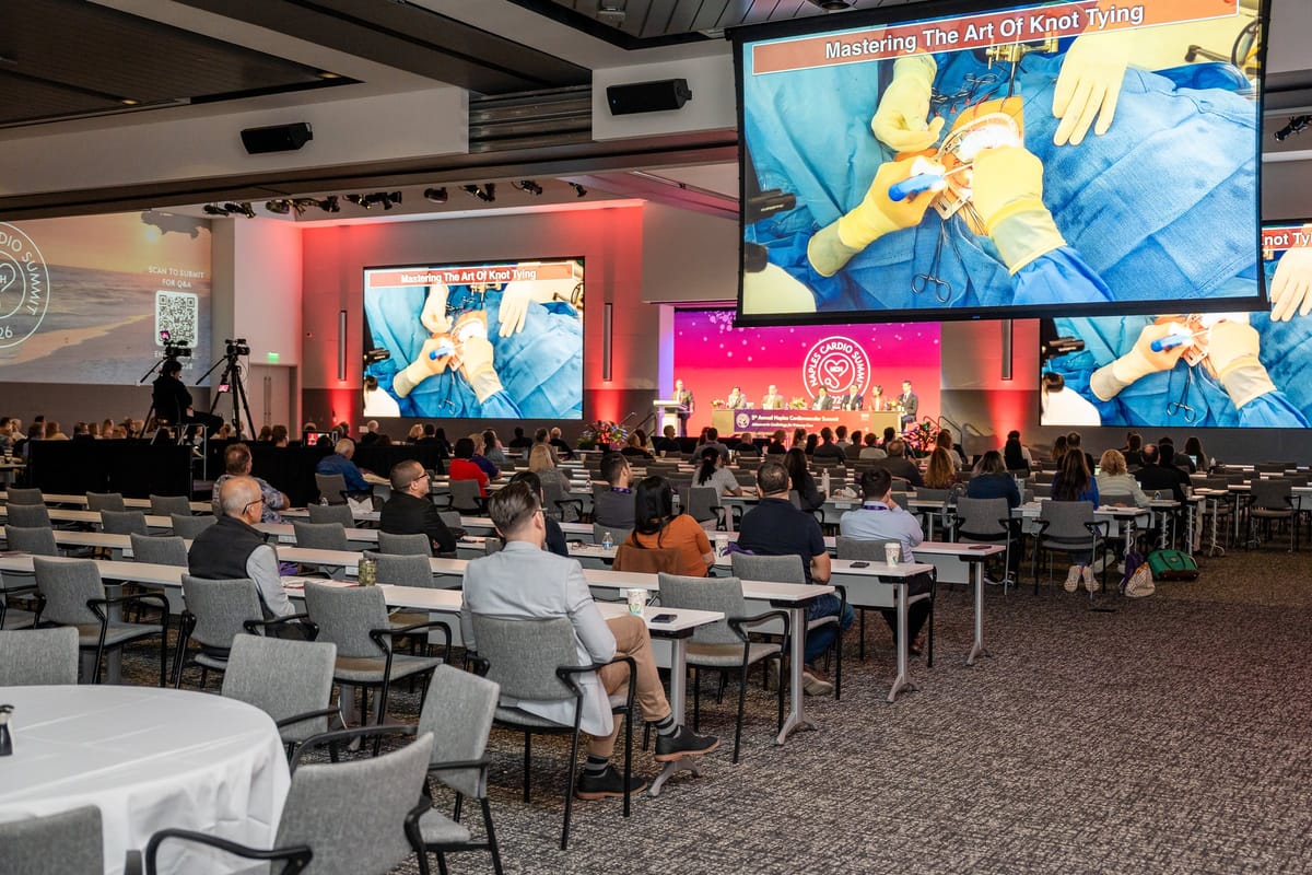 Cardiovascular clinical imagery displayed across the summit presentation screens